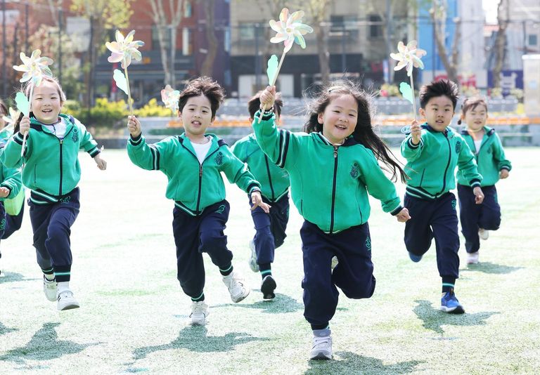 Trẻ em chạy với chong chóng tại Nhà thi đấu Suwon ở Suwon, tỉnh Gyeonggi - Ảnh: Yonhap