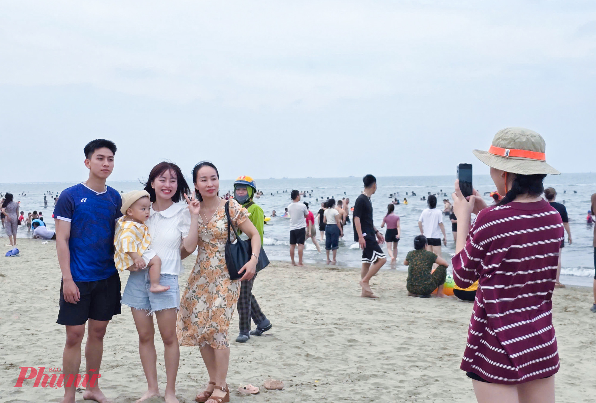Một gia đình lưu lại tấm ảnh kỷ niệm bên bãi biển Cửa Lò.