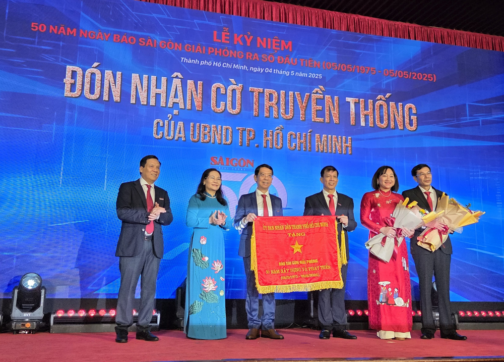 Lãnh đạo SGGP nhận cờ truyền thống của UBND TPHCM.