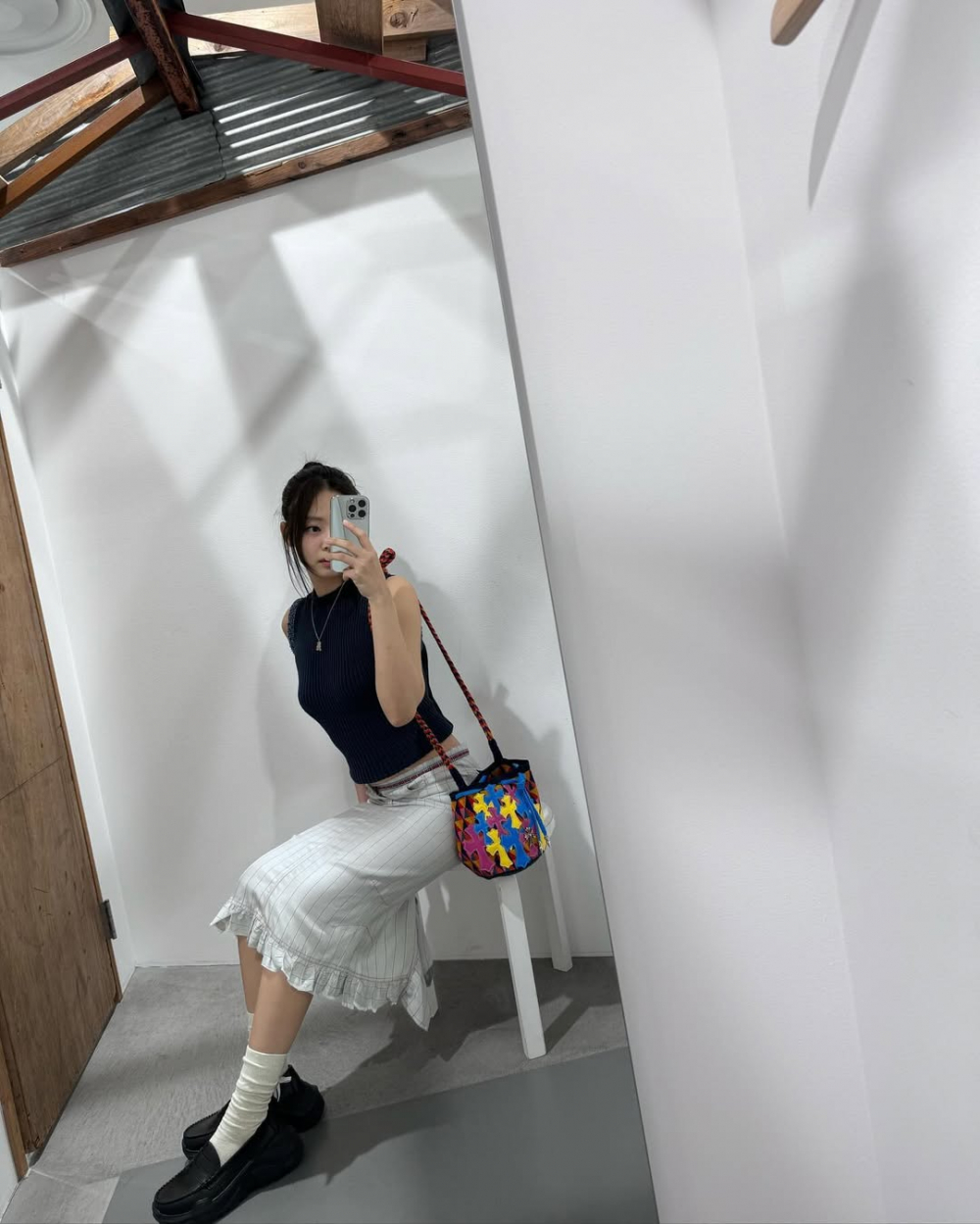 Giữa mùa Hè oi nồng, sự kết hợp giữa tank top và chân váy không đơn thuần là một lựa chọn mát mẻ, đó là cách kể chuyện bằng thời trang, nơi phong cách năng động gặp gỡ tinh thần nữ tính ngọt ngào và thanh lịch. Chiếc tank top ôm sát, mang đậm dấu ấn của những năm 90, khi được kết hợp cùng chân váy midi xòe nhẹ hoặc váy bút chì cạp cao sẽ gợi lại hình ảnh những nàng thơ “Parisian-chic“.   Nếu yêu tinh thần nổi loạn nhẹ nhàng, item này khi kết hợp cùng chân váy xòe họa tiết caro sẽ tạo nên một bảng phối đầy tính chuyển động giữa hoài niệm và hiện tại. Caro vẫn là họa tiết giữ nhiệt suốt mùa Hè, được phối cùng tất màu nổi và kính gọng lấp lánh, khiến cả tổng thể trở nên rực rỡ và đầy cá tính. 