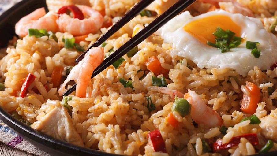 Nasi goreng là món cơm chiên đặc trưng của Indonesia, rất phổ biến trong ẩm thực đường phố và gia đình. Cơm nguội được chiên với tỏi, hành, ớt, nước tương ngọt (kecap manis) và các loại gia vị khác, tạo nên hương vị mặn mà và thơm phức. Món ăn thường được kèm với trứng chiên, gà, tôm, hoặc các loại thịt khác, cùng với dưa leo và bánh phồng tôm. Nasi goreng có thể biến tấu đa dạng tùy khẩu vị và nguyên liệu sẵn có. Đây là món ăn tiện lợi, ngon miệng và giàu năng lượng, thích hợp cho 