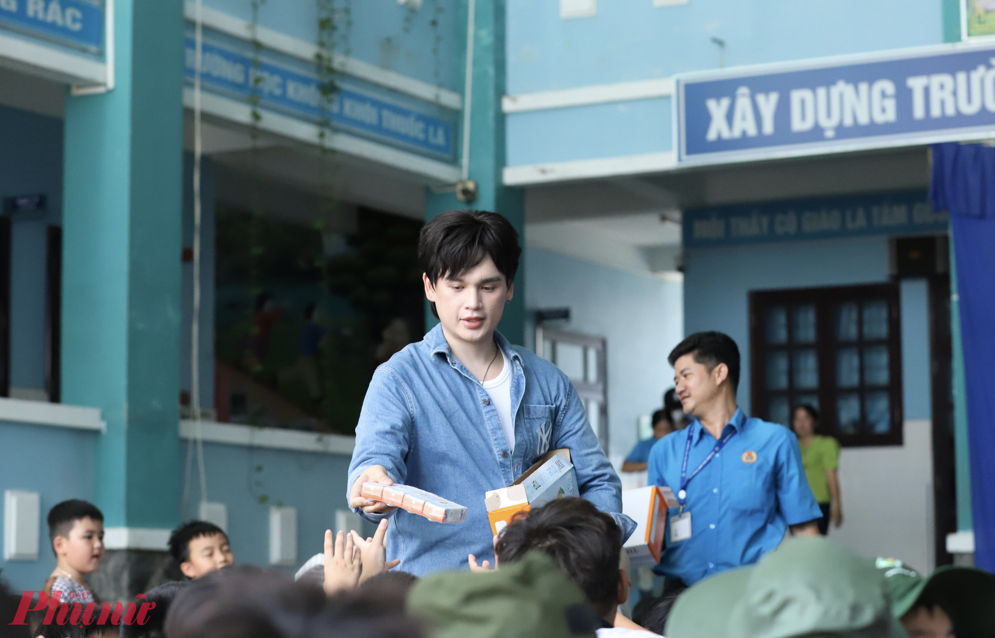Ca sĩ Nguyễn Trần Trung Quân phát sữa cho các em học sinh