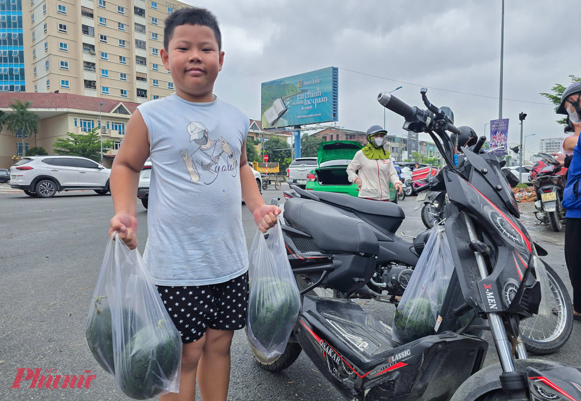 Bỏ vào thùng ủng hộ 200.000 đồng sau khi lấy 5 quả dưa hấu, em Phạm Xuân Quân (trú thành phố Vinh) cho biết, đang trên đường cùng mẹ đi chợ ngang qua thì thấy người dân giải cứu dưa hấu nên ghé vào mua ủng hộ. “Trời nắng này ăn dưa mát nên em nói với mẹ lấy thêm về vừa ăn dần vừa giúp tài xế gặp tai nạn” – Quân nói.