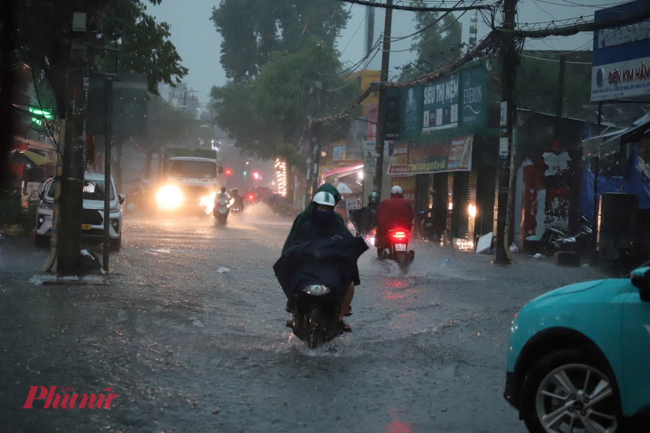 Trời tối mịt do mưa lớn từ sáng sớm khiến việc di chuyển vào giờ cao điểm trở nên nguy hiểm - Ảnh: Vũ Quyền