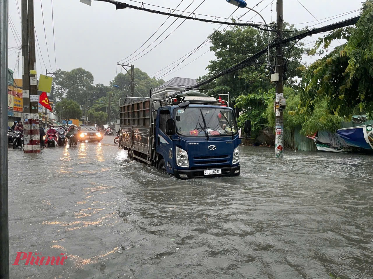 Nước ngập gần tới yên xe khiến nhiều phương tiện chết máy, chỉ có xe buýt, xe tải vẫn có thể di chuyển - Ảnh: Vũ Quyền