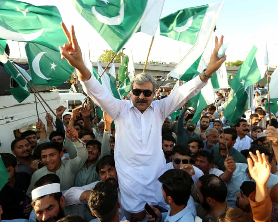 Người dân Pakistan giơ cao quốc kỳ ủng hộ quân đội - Ảnh: EPA