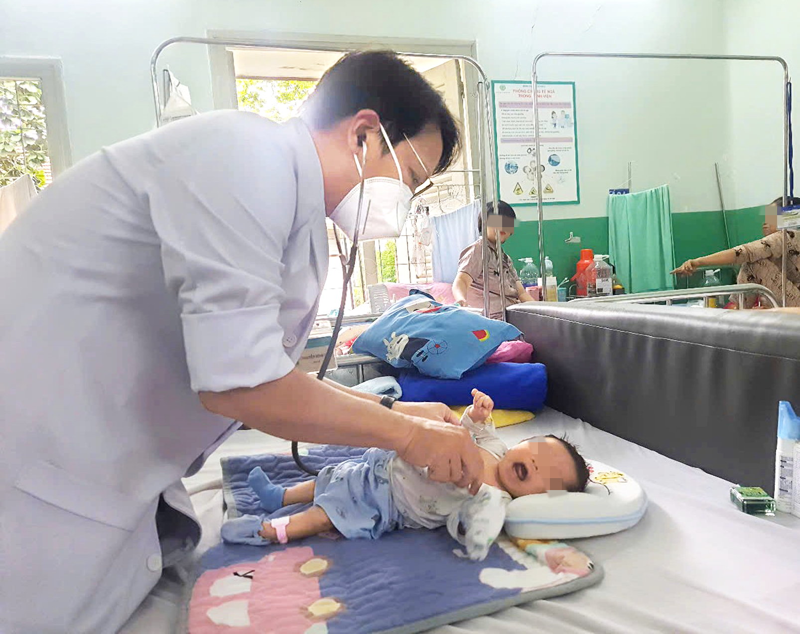 Bác sĩ Nguyễn Đình Qui khám cho trẻ mắc tay chân miệng