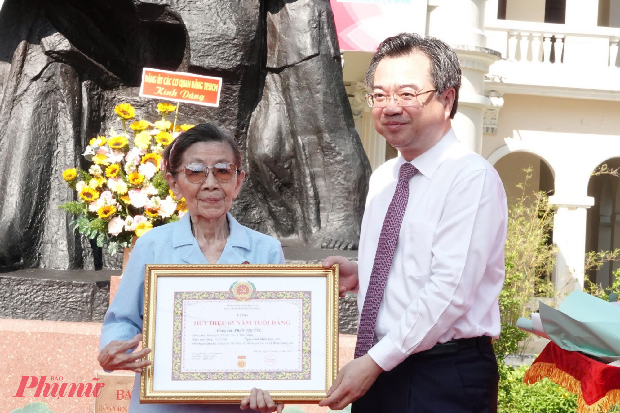 Ông Nguyễn Thanh Nghị trao huy hiệu 65 năm tuổi Đảng cho đảng viên Trần Thị Túc.