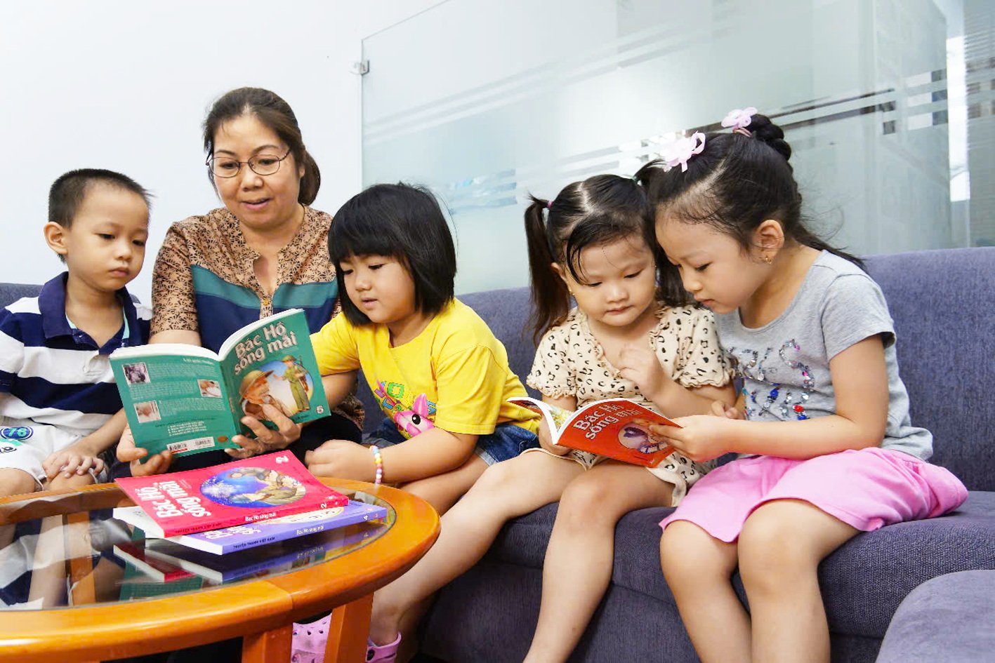 Mạch chảy của lòng yêu kính Bác Các em nhỏ say sưa đọc bộ sách Bác Hồ sống mãi - ẢNH: PHÙNG HUY