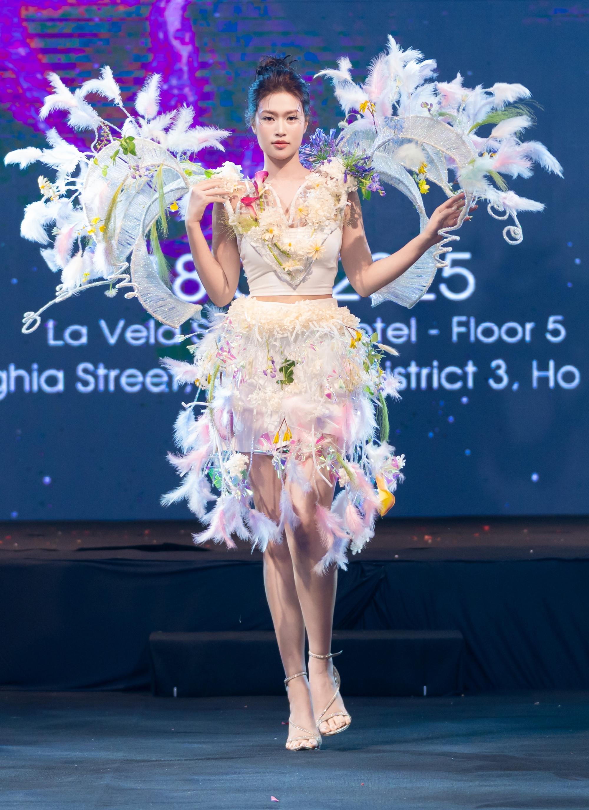 Hoa hậu Thiên Ân diện chiếc váy được đính kết hoa tông màu trắng, giúp tôn lên nhan sắc ngọt ngào của Miss Grand Vietnam 2022. Khi nàng hậu di chuyển, những bông hoa chuyển động theo từng bước chân, tạo cảm giác như một bản hòa ca giữa người mẫu, thời trang và hoa đầy sinh động.