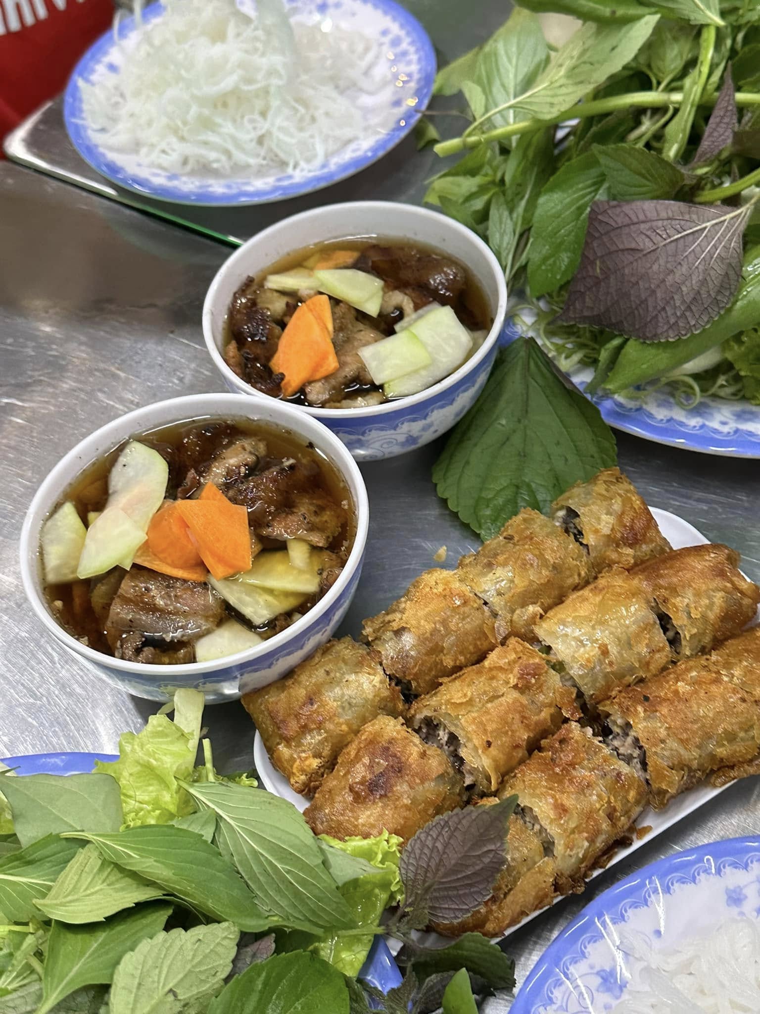 Bún chả Xuân Tứ gợi nhớ những buổi trưa Hà Nội nắng nhẹ, khi mùi thịt nướng dậy lên quyện trong gió. Chả viên tròn trịa, thơm nức, thịt lát nướng vàng óng, thấm vị đậm đà, thả vào chén nước mắm pha chua ngọt thanh thanh. Ăn kèm bún tươi, ít rau sống và vài lát đu đủ giòn giòn, mọi thứ hòa quyện vừa đủ, nhẹ nhàng mà đầy dư vị. Không gian nhỏ nhưng chỉn chu, phục vụ nhanh gọn, là nơi để dân văn phòng tìm chút bình yên và hương vị Bắc giữa nhịp sống gấp gáp. Địa chỉ: 26A Bùi Thị Xuân, P.2, Q.Tân Bình, TP.HCM Giờ mở cửa: 10:00 – 22:00 Giá: 30.000 – 50.000 đồng