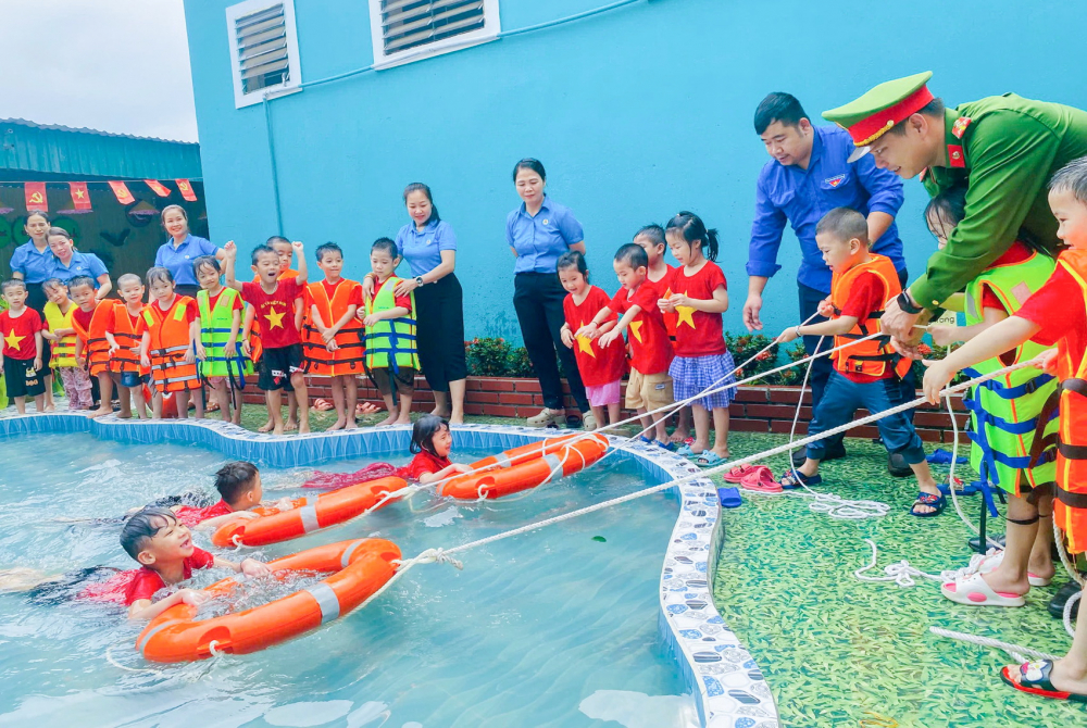 Ngăn thảm cảnh trẻ đuối nước mùa hè Đoàn viên thanh niên và công an hướng dẫn học sinh mầm non ở huyện Kỳ Sơn, tỉnh Nghệ An cách phòng tránh tai nạn đuối nước - Ảnh: Phan Ngọc