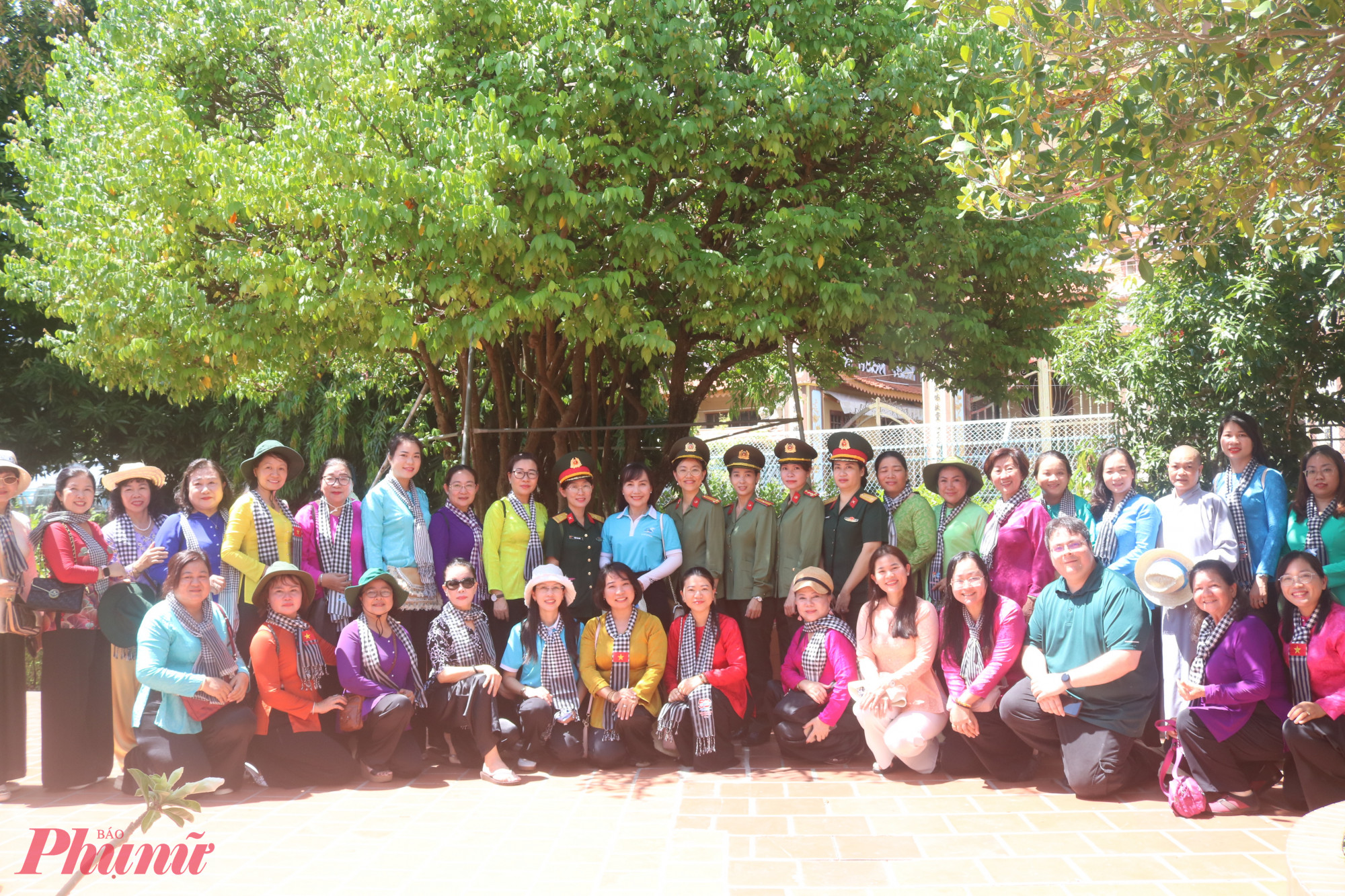 Đoàn chụp hình kỷ niệm bên cây khế được thầy giáo Nguyễn Tất Thành chăm sóc trong thời gian dạy học tại trường. 