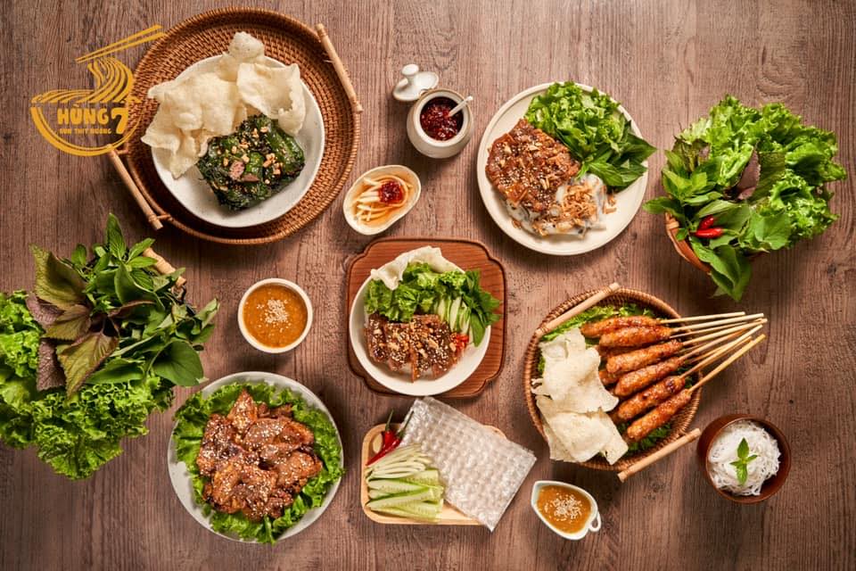 4. Bún thịt nướng, bún mắm nêm – Món khô, mát bụng Giữa ngày nóng bức, chỉ nghĩ tới việc ăn một tô bún nghi ngút khói đã thấy... đổ mồ hôi. Vậy nên, những món “bún khô” như bún thịt nướng hay bún mắm nêm luôn chiếm ưu thế. Bún nguội, rau sống giòn mát, thịt nướng thơm lừng, thêm chút đồ chua, đậu phộng và mỡ hành, chan nhẹ nước mắm pha hoặc mắm nêm đậm đà – đủ vị mà không nặng bụng. Món này còn có ưu điểm là no lâu mà không gây ngấy, lại bổ sung được rau xanh và chất đạm cần thiết. Một số quán được dân sành ăn yêu thích là Hải Đăng (Nguyễn Văn Đậu), bún mắm nêm Cô Ba (Trường Sa), hay các tiệm bún Đà Nẵng ở Vạn Kiếp. Giá mỗi tô dao động từ 35.000 – 55.000 đồng. Không ồn ào, không bốc khói, chỉ nhẹ nhàng thơm mát như một buổi trưa râm mát giữa lòng phố thị.
