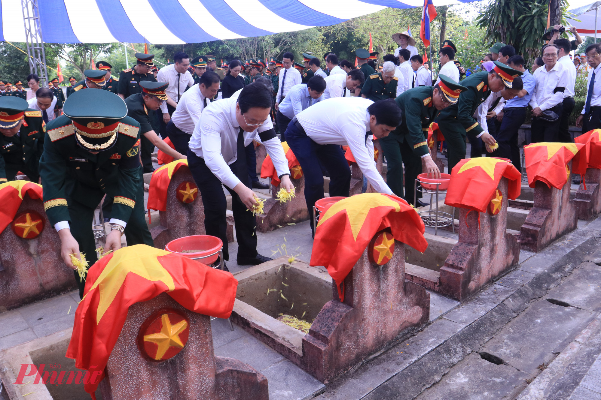 Lãnh đạo tỉnh Nghệ An cùng các đại biểu, người dân rải hoa xuống phần mộ các liệt sĩ.