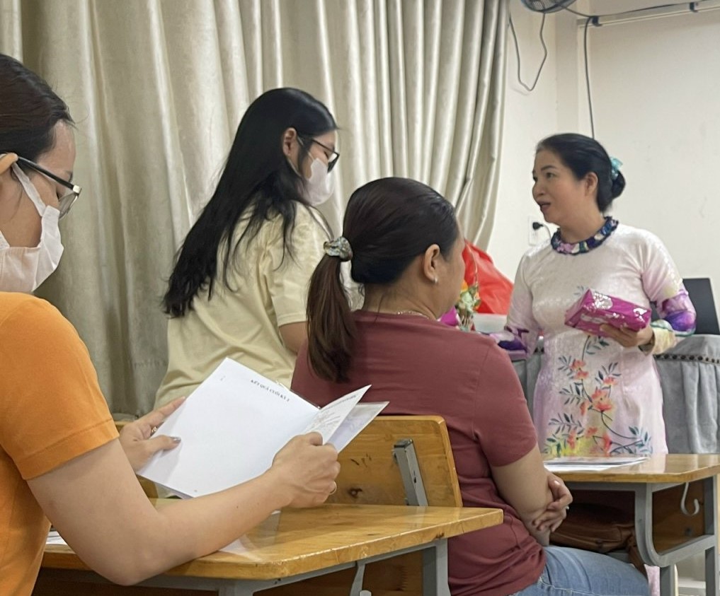 Cô Nguyễn Thị Hiệp trao quà cho phụ huynh để động viên các con - Ảnh: DHT