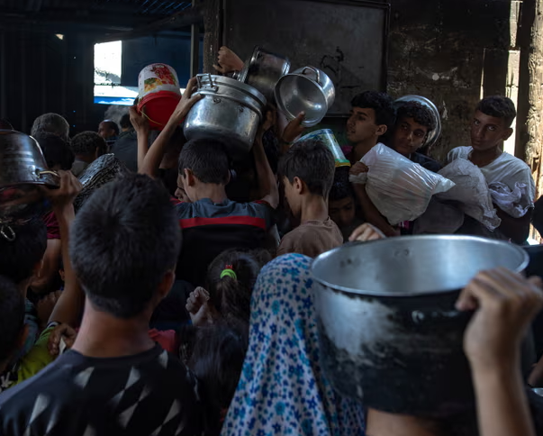 Những người Palestine di tản tụ tập bên ngoài một nhà bếp từ thiện để nhận khẩu phần thực phẩm ở thành phố Gaza. Ảnh: Haitham Imad/EPA