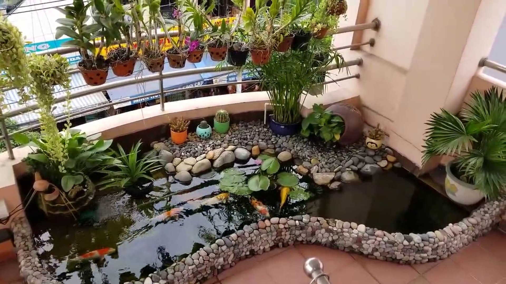 Khi trời nắng gắt, mặt nước trong hồ sẽ góp phần điều hòa nhiệt độ khu vực xung quanh, tạo hơi nước mát mẻ tự nhiên. Hồ cá cũng mang lại âm thanh sinh động, cảm giác gần gũi với thiên nhiên và là nơi thư giãn tuyệt vời sau một ngày làm việc căng thẳng.  4. Đặt thác nước hoặc đài phun nước mini Thác nước mini hay đài phun nước trong nhà không chỉ là vật trang trí phong thủy mà còn là giải pháp làm dịu không khí rất hiệu quả. Tiếng nước chảy róc rách có tác dụng xoa dịu tinh thần, làm mát không gian và mang lại cảm giác thư thái, đặc biệt trong những ngày hè oi ả. Bạn có thể chọn mua sẵn các mô hình nhỏ gọn, hoạt động bằng điện hoặc pin, được làm từ gốm, đá nhân tạo hoặc nhựa giả cổ. Thác nước mini phù hợp đặt ở phòng khách, lối vào nhà, góc thiền hoặc hành lang – nơi mọi người dễ dàng cảm nhận và hưởng thụ sự mát lành. Với người yêu phong thủy, dòng nước chảy tượng trưng cho sự hanh thông và tài lộc, rất đáng để đầu tư một góc nước nhỏ trong nhà.  5. Bố trí bể cá cảnh trong nhà Một bể cá cảnh trong phòng khách, phòng làm việc hoặc nhà bếp không chỉ nâng tầm thẩm mỹ mà còn giúp cải thiện đáng kể không khí trong nhà vào mùa nóng. Hệ thống lọc nước và máy bơm tuần hoàn trong bể sẽ duy trì độ ẩm ổn định, hạn chế tình trạng khô nóng của máy lạnh. Ngoài ra, sự hiện diện của nước và sinh vật sống như cá, rêu, tảo cũng góp phần điều hòa tâm trạng, mang lại sự cân bằng giữa các yếu tố trong nhà. Bạn có thể lựa chọn bể cá treo tường, để bàn hoặc âm tường tùy theo không gian và sở thích. Việc chăm sóc bể cá cũng là thú vui thanh lọc tinh thần, giúp người nuôi sống chậm hơn, quan sát và yêu thiên nhiên nhiều hơn giữa nhịp sống hiện đại -Ảnh: Dailymotion