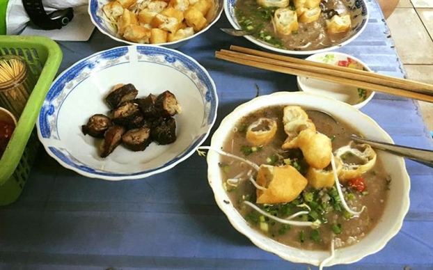 Nếu bạn là cú đêm hay cần một món ấm bụng lúc khuya, quán Cháo lòng 144 Phan Đăng Lưu (phường 3, quận Phú Nhuận) là điểm đến lý tưởng. Quán mở từ 14h đến 8h sáng hôm sau, phục vụ suốt đêm hơn 20 năm qua. Cháo nấu từ nước luộc lòng và xương heo, hạt gạo nhuyễn, thơm dịu, vừa miệng. Topping phong phú: gan bùi, lưỡi giòn, phèo béo, đặc biệt có dồi rán vàng giòn ăn kèm mắm cay cay, thêm chút tiêu, gừng là chuẩn bài cho đêm se lạnh.