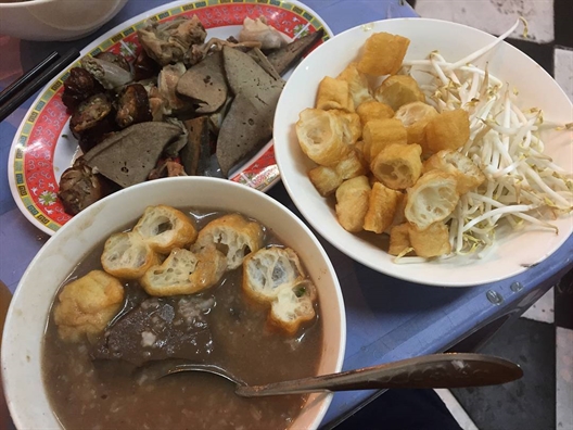 Cháo nấu từ nước luộc lòng và xương heo, hạt gạo nhuyễn, thơm dịu, vừa miệng. Topping phong phú: gan bùi, lưỡi giòn, phèo béo, đặc biệt có dồi rán vàng giòn ăn kèm mắm cay cay, thêm chút tiêu, gừng là chuẩn bài cho đêm se lạnh.  Không gian quán đơn sơ nhưng sạch sẽ, hiện đã mở rộng thoáng hơn. Giá bình dân, chỉ từ 15.000 – 22.000 đồng/tô, phù hợp mọi đối tượng.