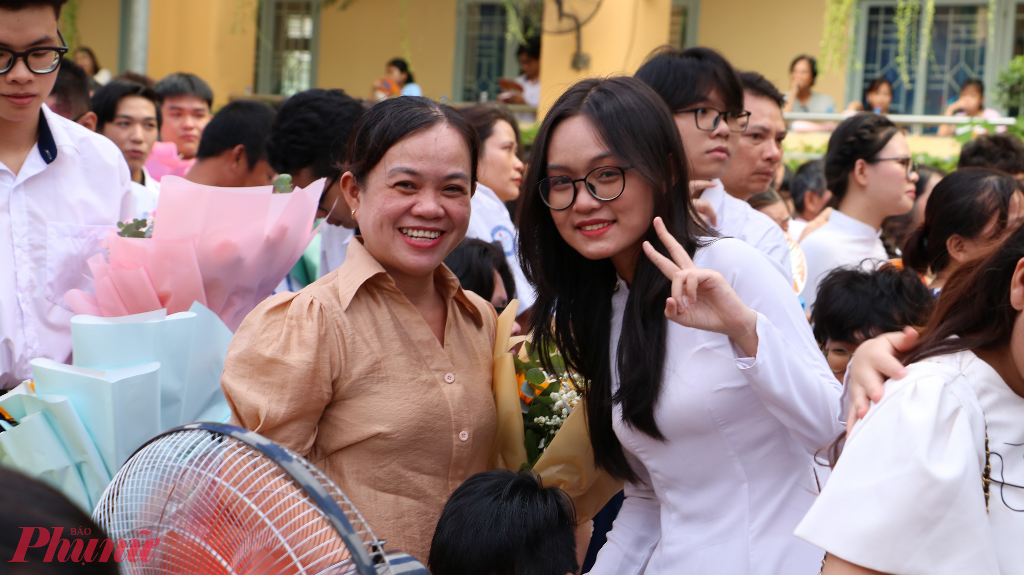 Học sinh chụp ảnh cùng cha mẹ trong ngày trọng đại của đời mình 