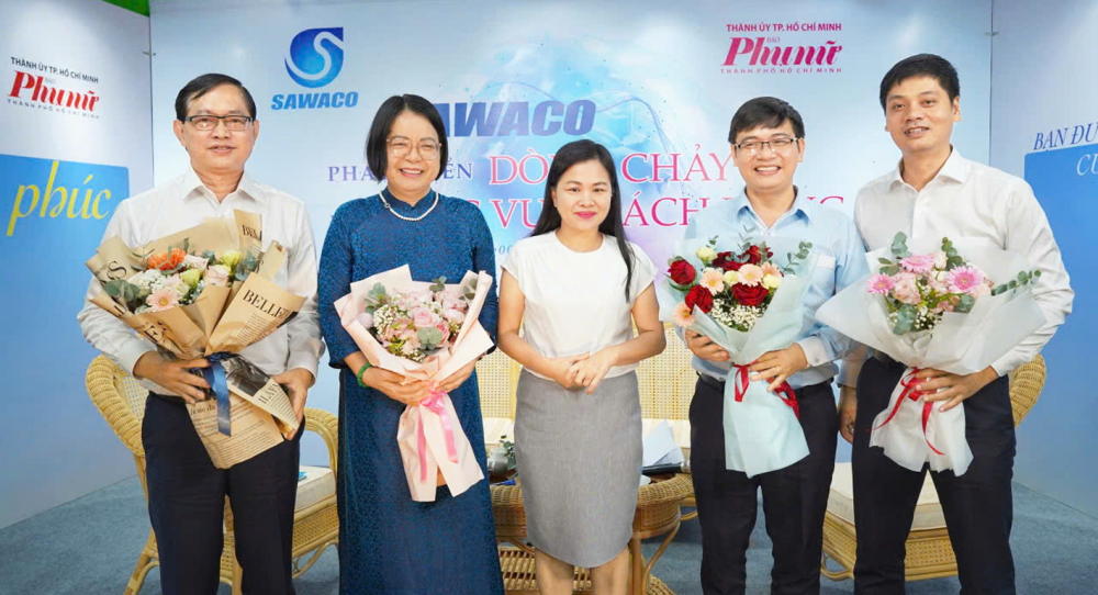 Dùng dòng chảy số nâng chất lượng dòng chảy nước sạch Bà Phạm Thị Vân Anh (giữa) - Phó tổng biên tập Báo Phụ nữ TPHCM - tặng hoa cảm ơn các đại biểu tham gia chương trình - ẢNH: N.QUANG