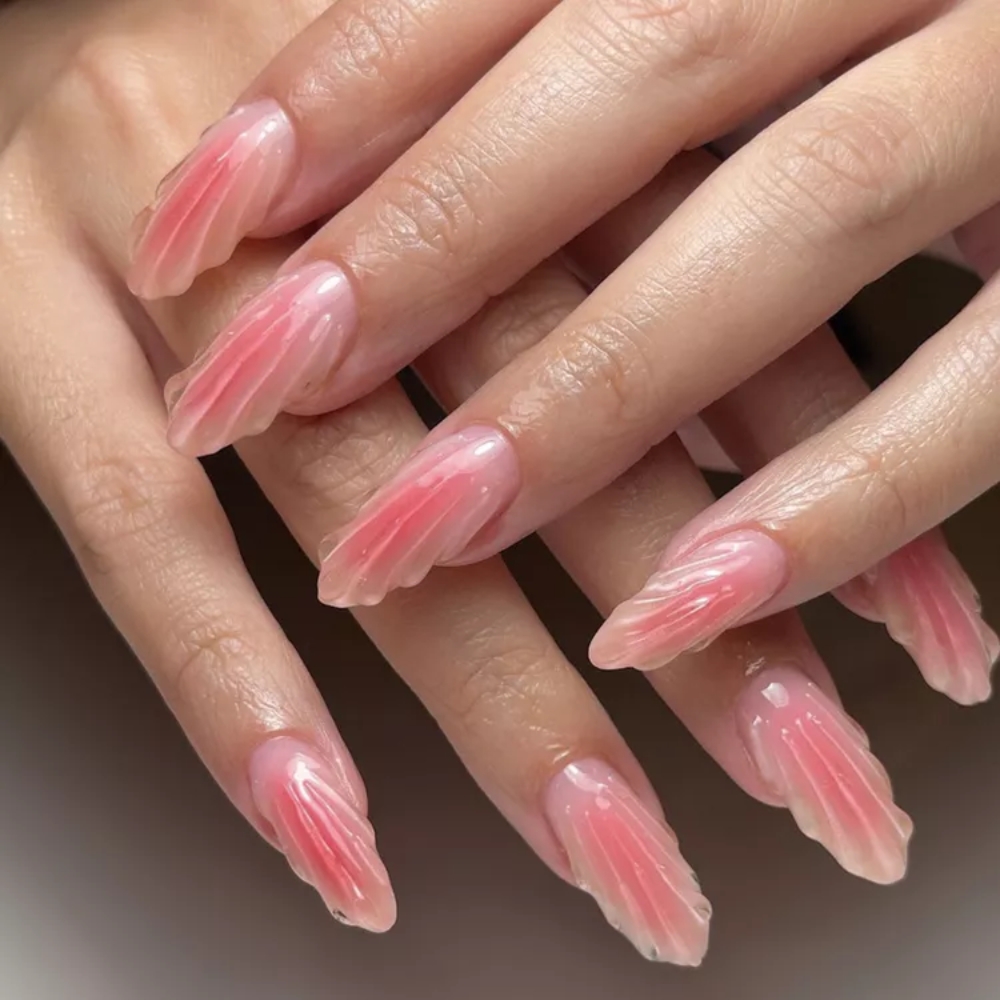  Mẫu nail họa tiết san hô: Không chỉ là một thiết kế móng, đây là cách để bạn kể câu chuyện hoàng hôn trên biển bằng sắc màu và đường nét. Sự chuyển sắc nhẹ nhàng giữa cam san hô và ánh nhũ tinh tế gợi nhắc vẻ đẹp trong trẻo, nguyên sơ của đại dương. Những chi tiết vỏ sò điêu khắc tỉ mỉ chính là điểm nhấn thủ công độc đáo, giúp đôi tay trở nên nổi bật và cuốn hút như một “món trang sức” mùa Hè.