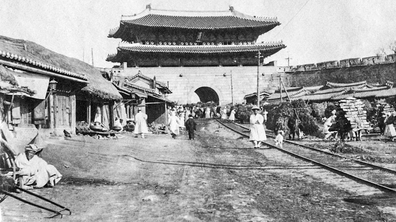 Namdaemun ban đầu là một trong ba cổng chính ở thành phố Seoul. Việc xây dựng bắt đầu vào năm 1395 và hoàn thành vào năm 1398. Cổng được xây dựng lại vào năm 1447 và được cải tạo nhiều lần trong những năm qua. Bức ảnh này được chụp vào 1904