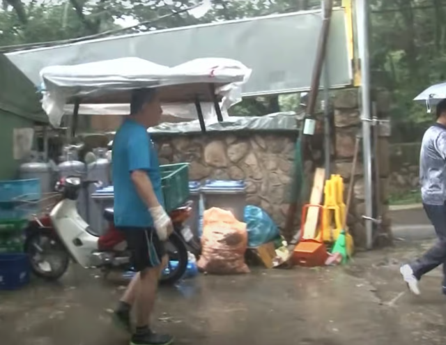 Vào những ngày mưa, ông chủ quán ăn chỉ cần phủ một tấm nhựa lên bàn và biến nó thành một chiếc ô trên thực tế. Ảnh: YouTube