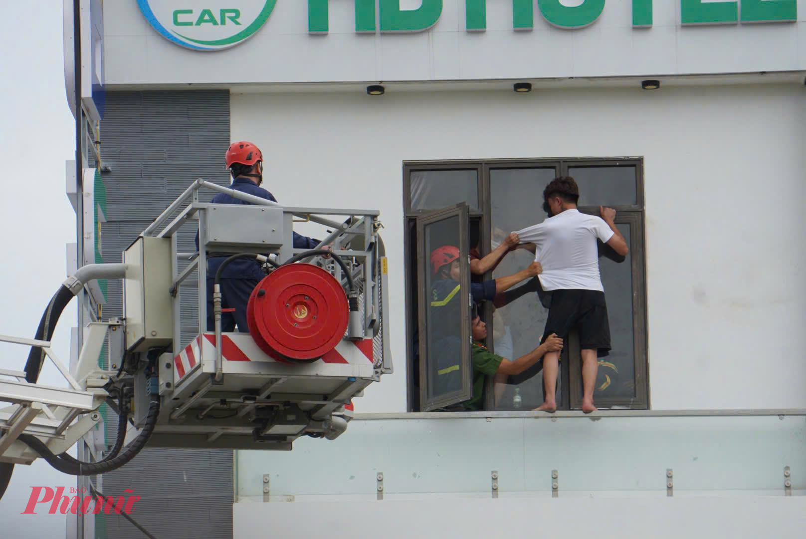 Cảnh sát cứu hộ phải điều xe thang chuyên dụng và nhiều biện pháp nghiệp vụ nhằm tiếp cận và kéo thanh niên này vào