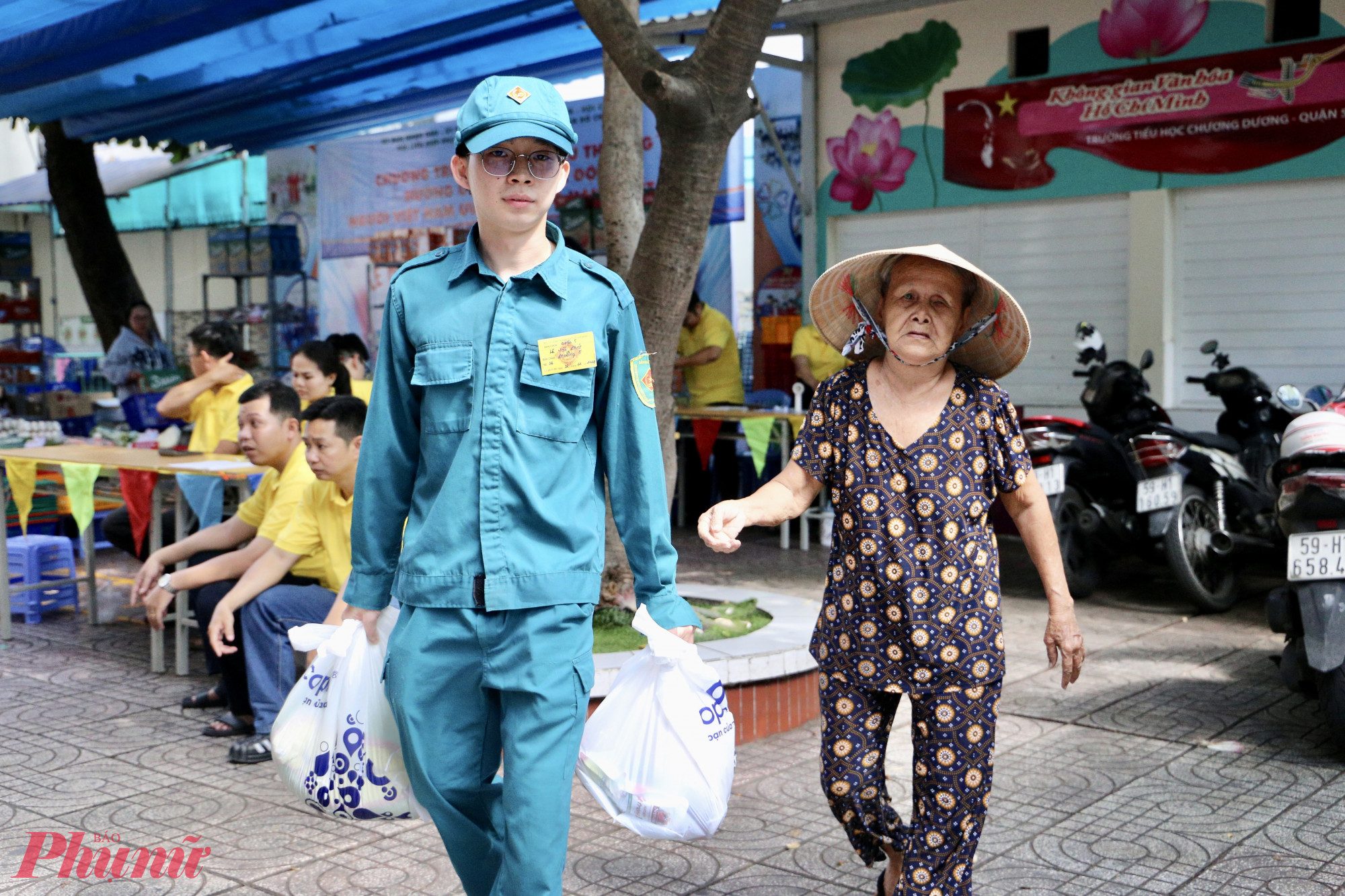 Lực lượng dân quân và đoàn thể hỗ trợ người dân mang hàng hóa ra tận nơi - Ảnh: Thanh Tâm
