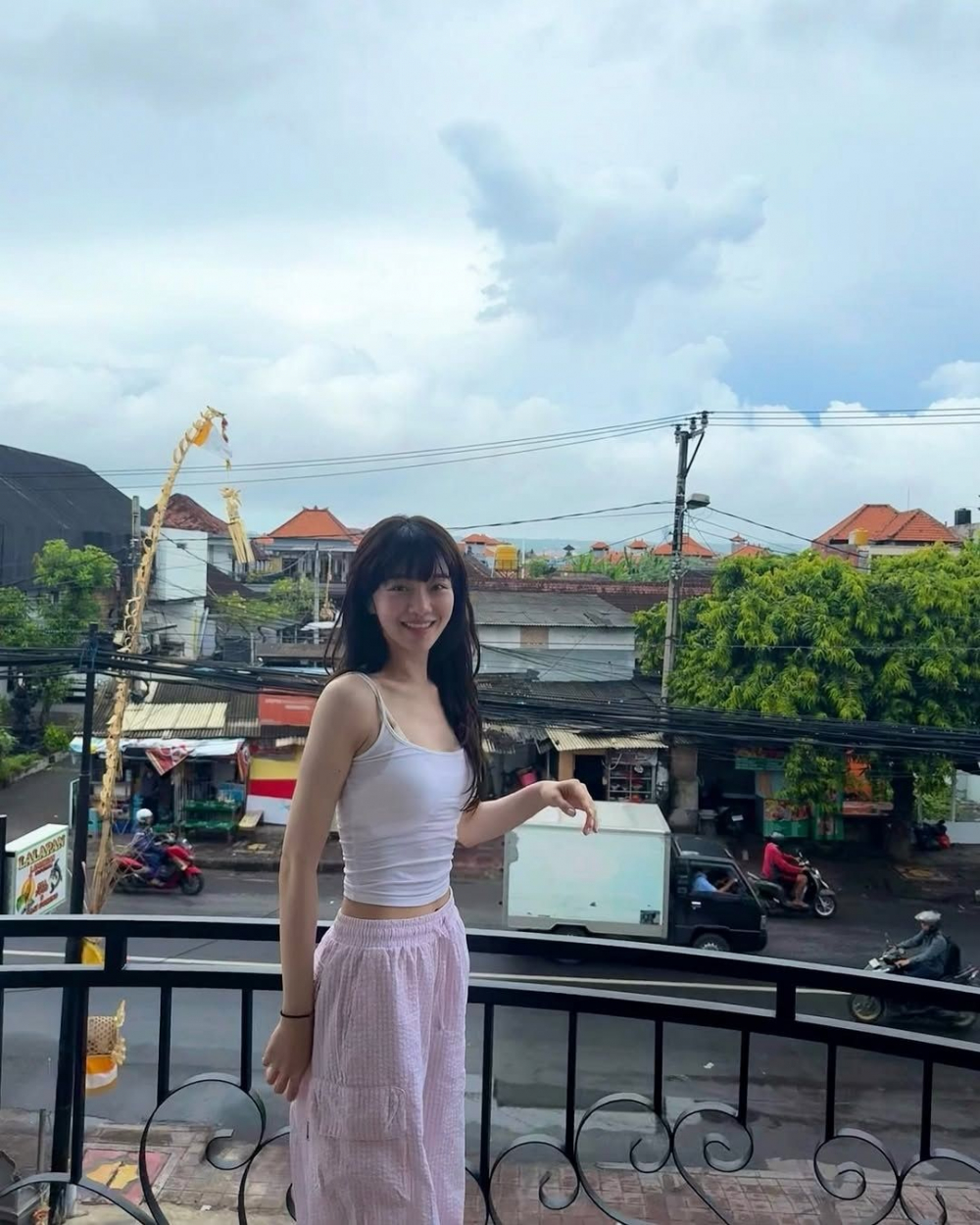 Park Gyu Young lại mang đến một cách tiếp cận mềm mại hơn: cô layer camisole nude cùng áo thun trắng ôm sát bên trong, kết hợp với quần seersucker sáng màu. Kiểu phối đồ này tạo cảm giác mát mẻ, nhẹ nhàng mà vẫn giúp tôn dáng, rất phù hợp cho những ngày nắng oi bức.