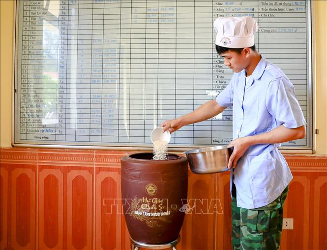 Tại Đồn Biên phòng Mường Mươn (huyện Mường Chà, tỉnh Điện Biên), trước mỗi giờ nấu cơm, chiến sĩ lại bớt một bát gạo để cho vào “Hũ gạo Chiến sĩ”. Ảnh: Xuân Tư/ TTXVN