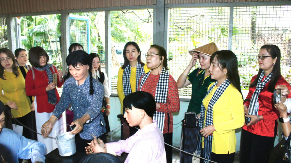 Bà Vũ Minh Nghĩa (thứ tư từ phải sang) giới thiệu di tích lịch sử Quán Nhan Hương - căn cứ bí mật của lực lượng biệt động Sài Gòn