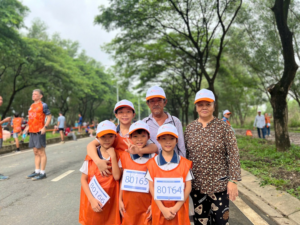 Đôi chân nhỏ chạm đích bằng trái tim lớn Chí Tâm cùng ông bà và các em trai trước giờ xuất phát. Ảnh: Quốc Thái