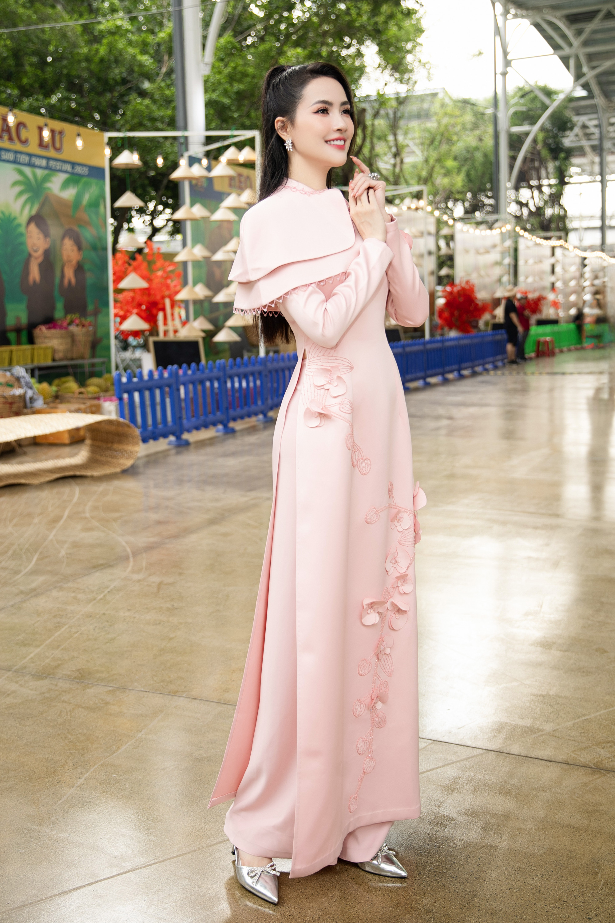 Tại sự kiện, nàng hậu quê Tiền Giang gây ấn tượng với chiếc áo dài tông hồng pastel được cách điệu ở phần cổ và vai, giúp tôn lên nhan sắc trẻ trung. Phan Thị Mơ bày tỏ niềm vinh hạnh khi được ban tổ chức tin tưởng trao vai trò đại sứ 