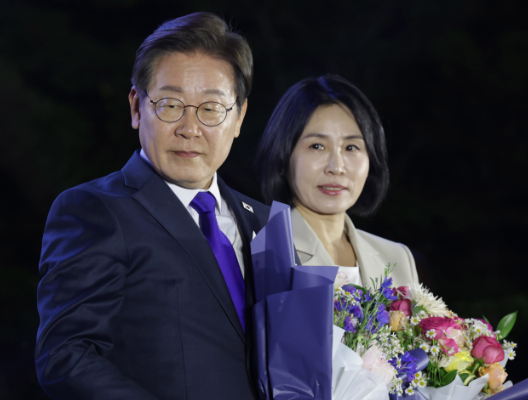 Tổng thống Lee Jae-myung (trái) và đệ nhất phu nhân Kim Hye-kyung nhận bó hoa trong một sự kiện kiểm phiếu công khai do Đảng Dân chủ Hàn Quốc tổ chức gần Quốc hội ở Yeouido, Seoul hôm thứ Tư. (Quân đoàn Báo chí Liên hợp)