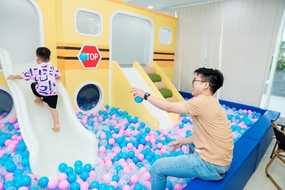 Panda Family & Kids Café tại số 33 Lương Minh Nguyệt, Tân Phú là điểm đến lý tưởng cho các gia đình có trẻ nhỏ. Không gian rộng rãi khoảng 260m², được thiết kế hiện đại và an toàn, với nhiều khu vui chơi như nhà banh, hồ hạt, khu trang điểm, quầy câu cá và khu vận động. Đồ chơi tại đây luôn được cập nhật mới, đảm bảo vệ sinh và an toàn cho trẻ. Quán phục vụ đồ ăn nhẹ và nước uống với mức giá hợp lý, từ 10.000 đến 25.000 đồng. Đặc biệt, có nhân viên hỗ trợ trông trẻ, giúp phụ huynh yên tâm thư giãn hoặc làm việc. Giá vé tham khảo từ 60.000 đồng, mở cửa từ 9h đến 21h (thứ Hai đến thứ Sáu) và từ 8h đến 21h30 (cuối tuần). Panda Family & Kids Café là lựa chọn tuyệt vời cho những buổi hẹn hò gia đình trọn vẹn.