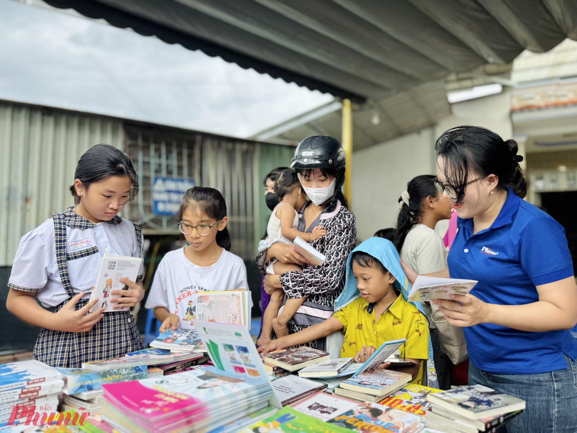 Các em học sinh tham quan gian hàng trưng bày sách, truyện thiếu nhi.