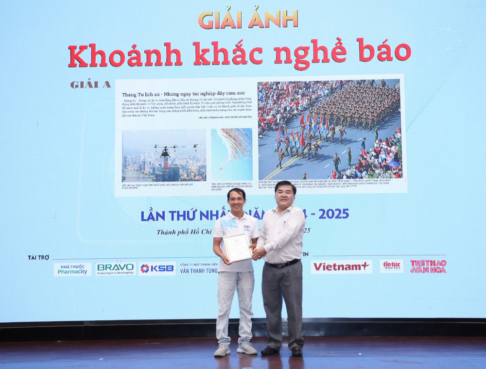 Trao giải cuộc thi ảnh “Khoảnh khắc nghề báo” Ông Nguyễn Quốc Tuấn, Giám đốc Trung tâm thông tin TTXVN trao giải A cho phóng viên Lê Mạnh Linh