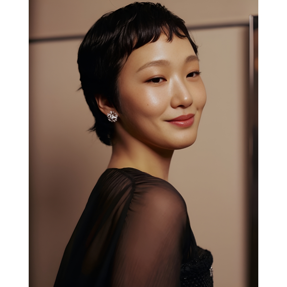 Trên thảm đỏ Cannes 2025, Kim Go Eun khiến công chúng phải trầm trồ khi xuất hiện với kiểu tóc pixie cực ngắn, kết hợp phần mái uốn cong nhẹ nhàng. Kiểu tóc này không cần sự cầu kỳ hay điệu đà, với các đường cắt ngắn gọn sát hai bên và gáy, phần mái siêu ngắn để lộ rõ nét trán và gò má, tạo nên sự cân bằng hoàn hảo giữa vẻ đẹp cổ điển và hiện đại. Với gương mặt trái xoan hơi tròn, Kim Go Eun sở hữu đặc điểm lý tưởng để kiểu tóc này tôn lên, giúp khuôn mặt trở nên thon gọn hơn. Đặc biệt, phần micro-bangs làm nổi bật đôi mắt, mang đến một diện mạo sắc sảo và đầy cuốn hút.