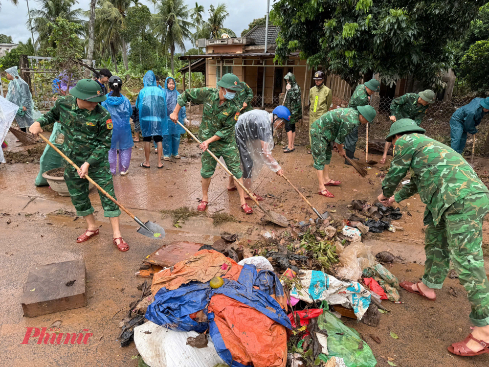 Tại đây các chiến sĩ Đồn biên phòng cửa khẩu Quốc tế Lao Bảo đang giúp dân thu gom rác thải, và bùn non đọng lại sau cơn lũ bất ngờ