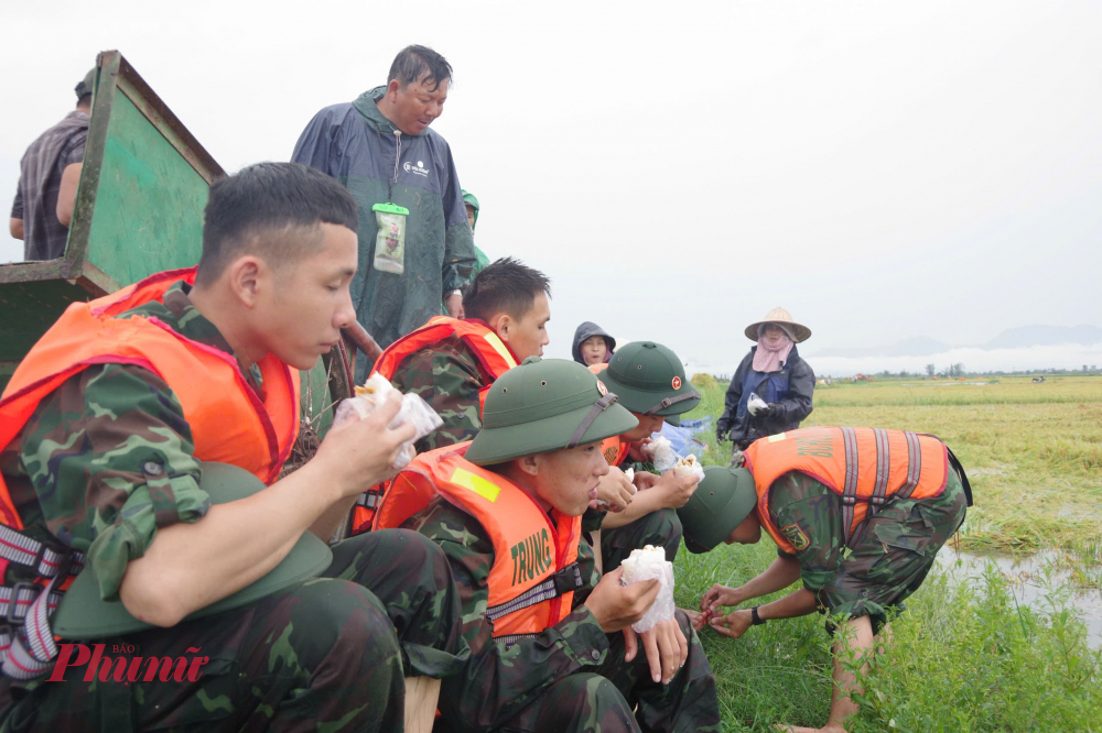 tranh thủ bữa ăn sáng trên đồng ruộng các chiến sĩ lại tiếp tục công việc gặt lúa giúp dân