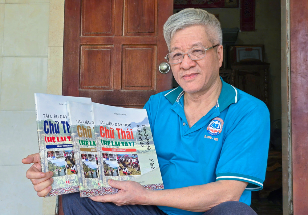 Những già làng nặng lòng với chữ Thái cổ Ông Sầm Văn Bình bên bộ sách dạy học chữ Thái hệ Lai tay - ẢNH: PHAN NGỌC