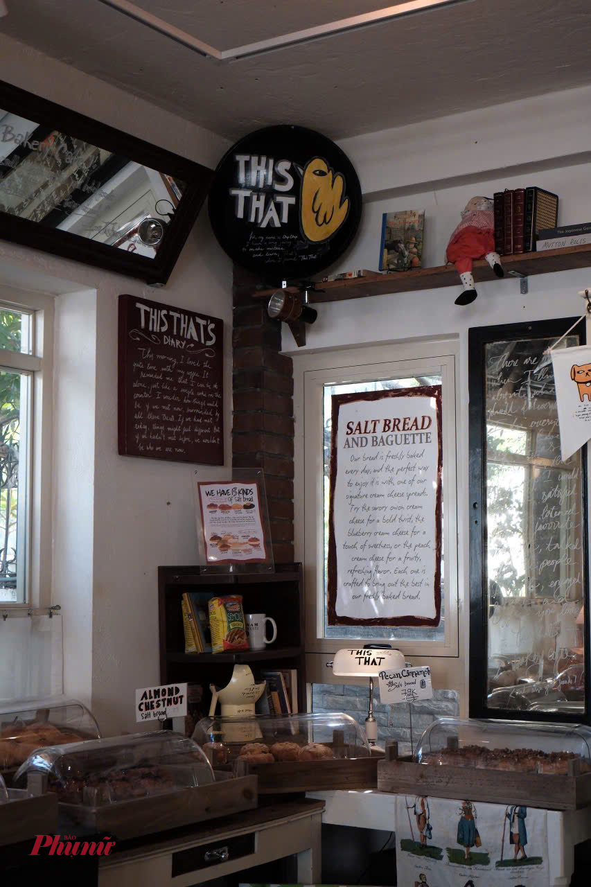 Nằm gọn trong một góc nhỏ yên bình của Quận 2, This That Bakery Cafe (đường Đặng Hữu Phổ, Thảo Điền) không chỉ là một tiệm bánh & quán cà phê đơn thuần, mà còn là điểm dừng chân lý tưởng cho những ai muốn 'né cái nắng gắt của Sài Gòn. Quán có không gian rộng rãi, kết hợp giữa phong cách tối giản hiện đại và sự ấm cúng kiểu cổ điển. Quán sử dụng nhiều cửa kính lớn để đón ánh sáng tự nhiên, nhưng được bố trí khéo léo để không bị nắng gắt. Bên trong là tông màu gỗ nâu trầm, kết hợp với cây xanh tạo cảm giác dễ chịu, gần gũi. Ảnh Myngoc_Vo