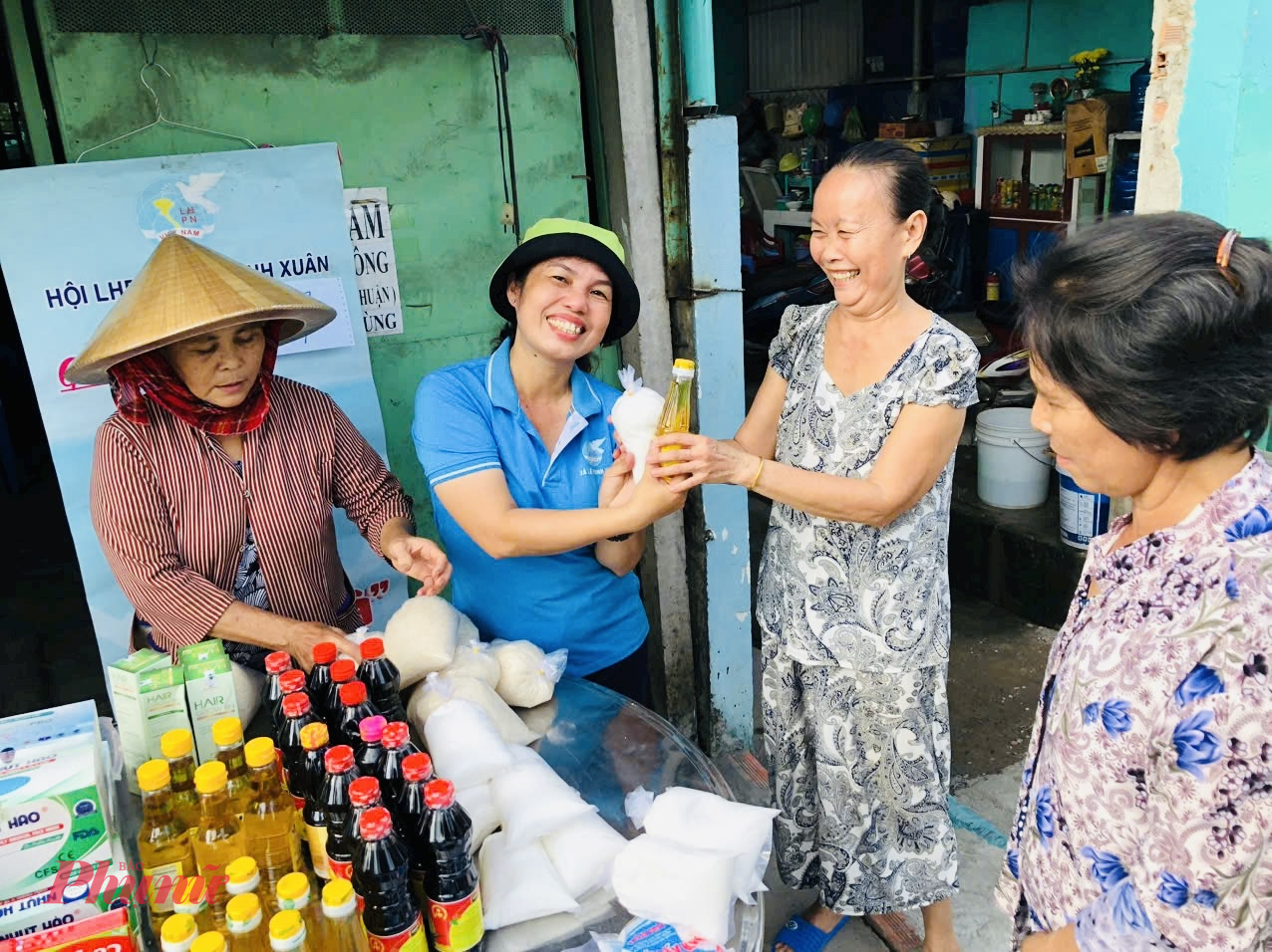 Bà Lê Minh Hoài – Chi hội trưởng Chi hội Phụ nữ ấp 17 trao quà cho người dân tham gia đổi rác  