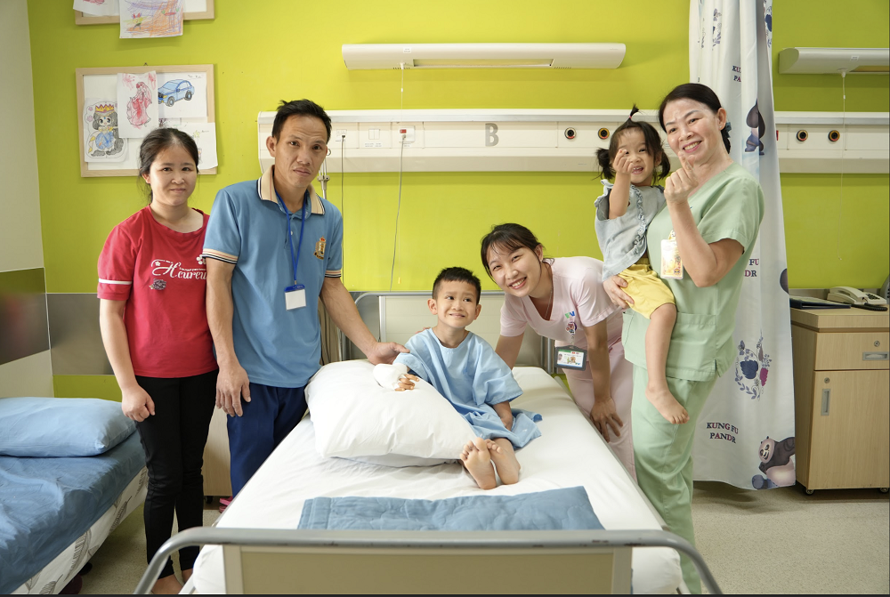 Bé Duy Quang chụp hình kỷ niệm cùng ba mẹ và các điều dưỡng của bệnh viện - Ảnh: FV