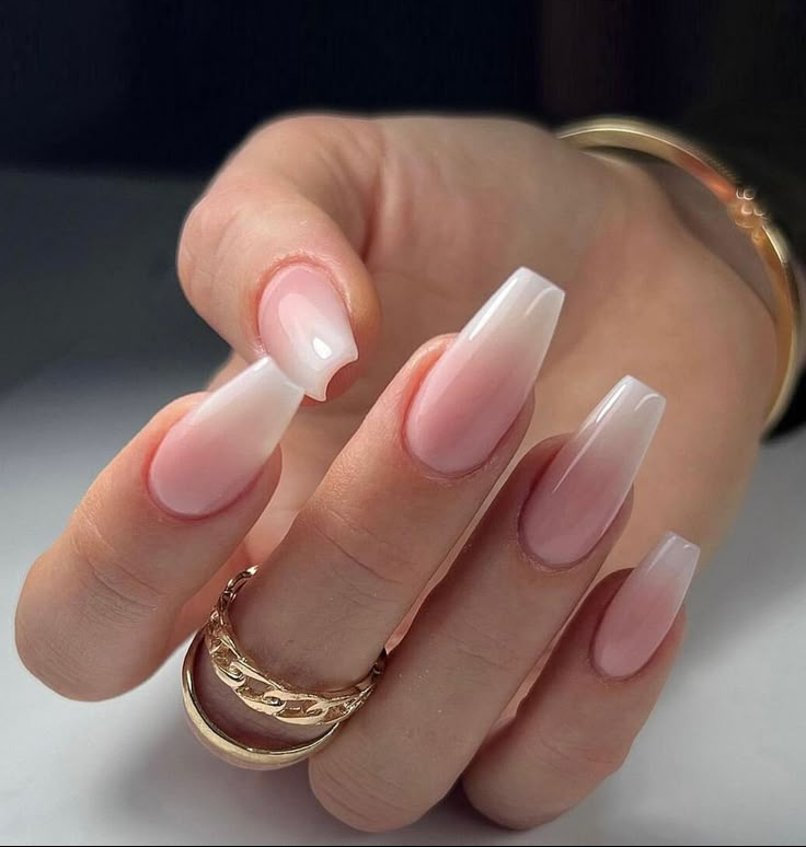 Móng ombre trắng hồng dáng vuông dài. Hiệu ứng chuyển màu từ hồng phấn sang trắng trong mang lại cảm giác tự nhiên, nhẹ nhàng mà không nhạt nhoà. Dáng móng vuông dài không chỉ làm thon gọn đầu ngón tay mà còn tăng độ sắc nét cho toàn bộ bàn tay. Sự kết hợp giữa gam màu mềm mại và đường nét mạnh mẽ tạo nên mẫu móng phù hợp với những ngày hè bận rộn nhưng vẫn muốn giữ lại chút dịu dàng trên đầu ngón tay.