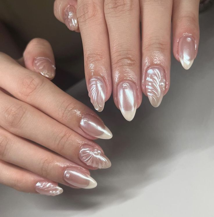 Móng vỏ sò ánh chrome Lấy cảm hứng từ bờ cát và vỏ sò dưới ánh nắng, mẫu móng này tạo hình gợn nổi như từng vệt sóng nhỏ in trên nền trắng ánh kim. Lớp chrome phản chiếu ánh sáng nhẹ, mang đến cảm giác mát lành như hơi biển len vào đầu ngón tay. Một thiết kế vừa gợi mở không khí mùa hè vừa giữ được nét tinh xảo và thanh thoát.