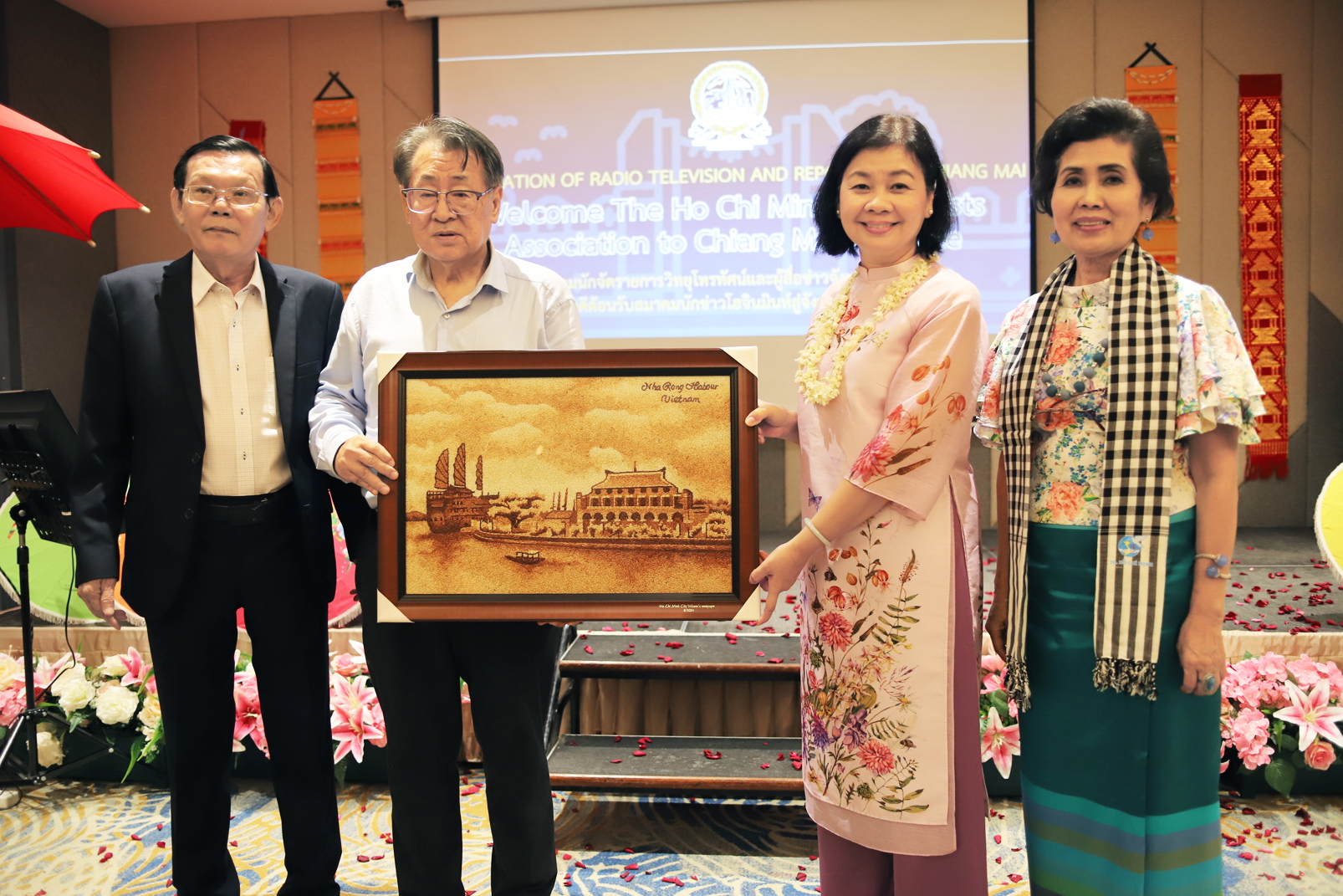 Nồng ấm tình đồng nghiệp báo chí TPHCM và Chiang Mai Ông Nguyễn Tấn Phong (bìa trái) - Chủ tịch Hội Nhà báo TPHCM - và bà Lý Việt Trung (thứ hai từ phải qua) - Phó chủ tịch Hội Nhà báo TPHCM, Tổng biên tập Báo Phụ nữ TPHCM - tặng tranh lưu niệm cho ông Amnat Jongyotying - Chủ tịch Hội Nhà báo tỉnh Chiang Mai - và phu nhân trong chuyến thăm tỉnh Chiang Mai tháng 8/2024 - ẢNH: SƠN VINH